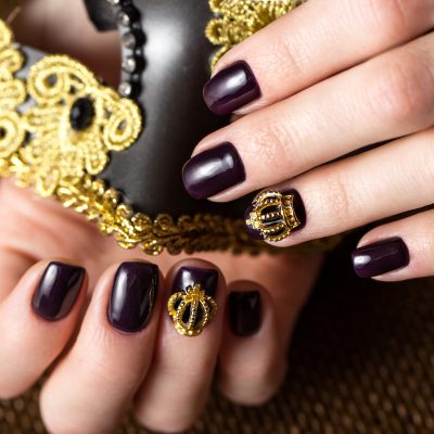 Black female manicure nails closeup with crown.